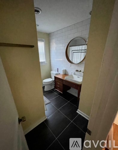 A bathroom with a toilet, sink, and mirror.