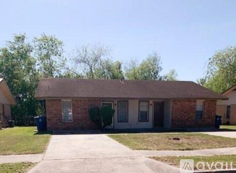 A brick house with a grey door and a small front yard.