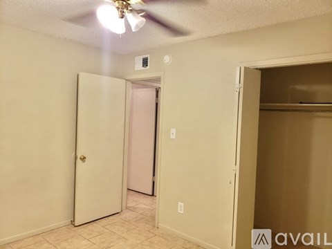 A room with a ceiling fan and a door.