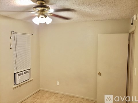 A room with a ceiling fan and a window with blinds.
