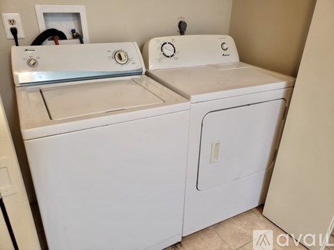 A white washing machine and dryer in a small room.