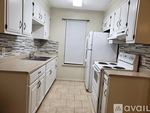 A kitchen with white cabinets and appliances.