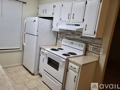 A kitchen with white appliances and cabinets.