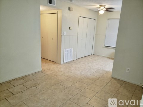 A room with a tile floor and a ceiling fan.