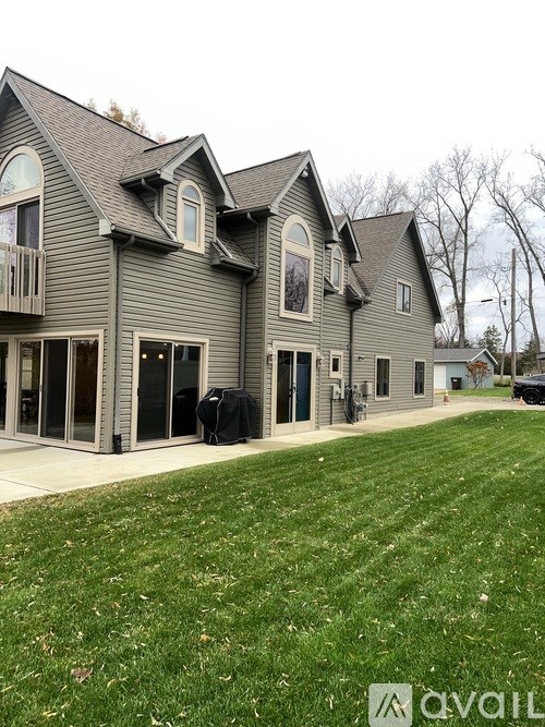 A house with a grey exterior and a black tarp covering the windows.