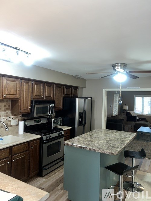 A kitchen with a granite counter top and a refrigerator.