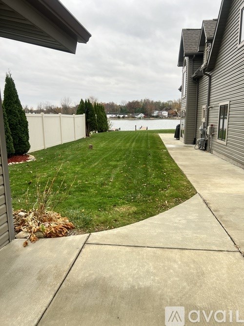 A house with a green lawn and a white fence.