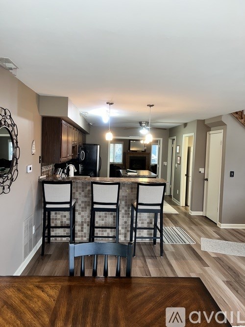 A kitchen with a wooden table and chairs in front of a bar area.