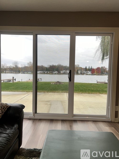 A patio door with a view of a lake and trees.