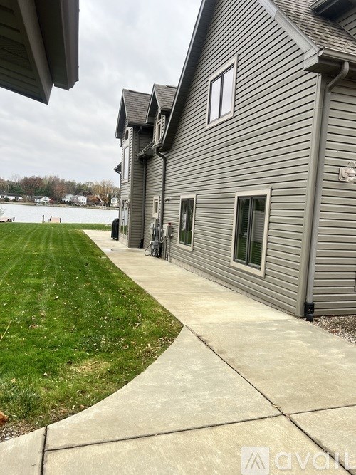 A house with a grey siding and a white window.