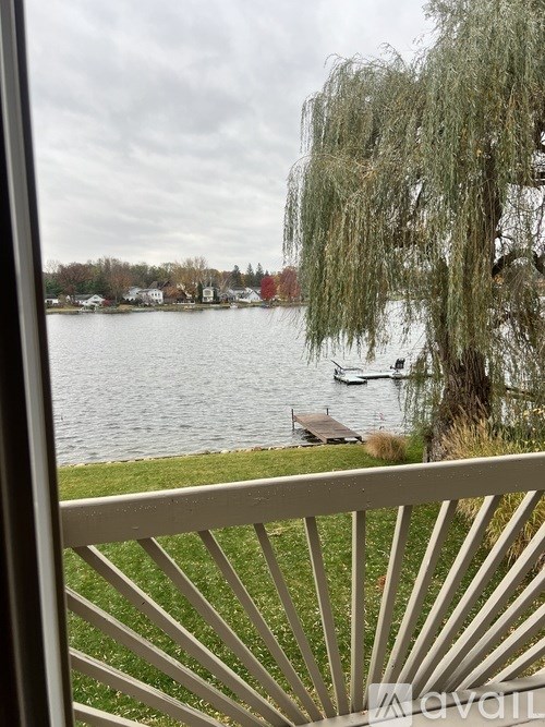A view of a lake from a balcony with a bench.