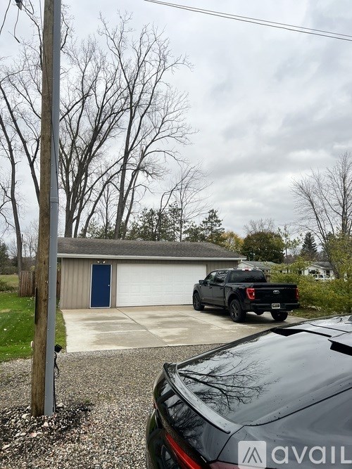 A black truck is parked in front of a garage.