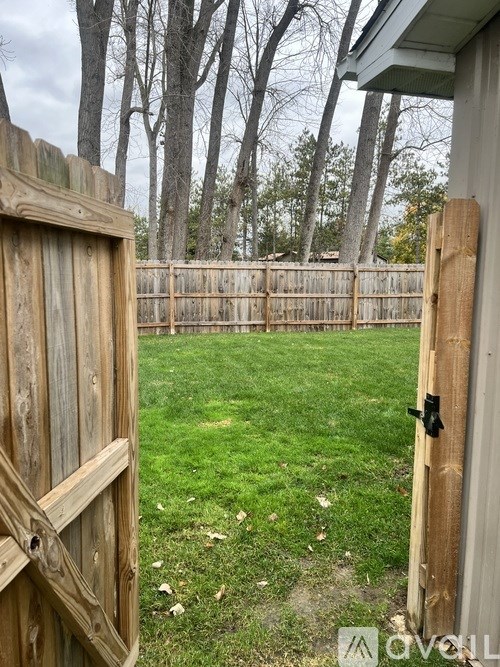 A wooden fence and gate in a yard.
