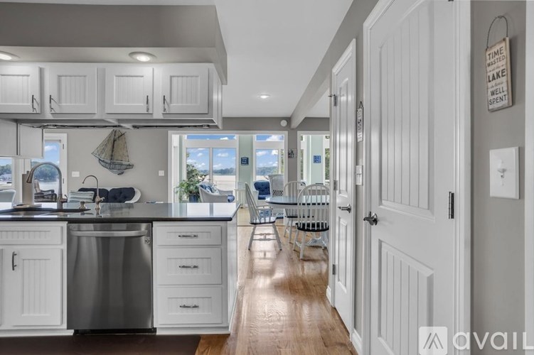 A kitchen with white cabinets and a wooden floor.