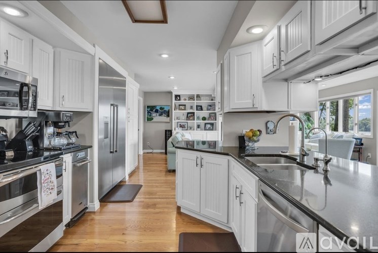 A modern kitchen with white cabinets and stainless steel appliances.