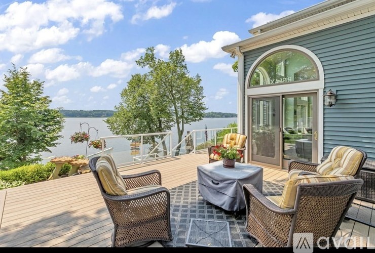 A patio with a table and chairs overlooking a body of water.