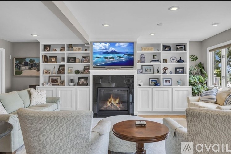 A living room with a fireplace and a television on the wall.
