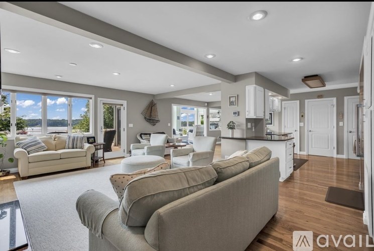 A spacious living room with a couch, a coffee table, and a large window overlooking the outdoors.