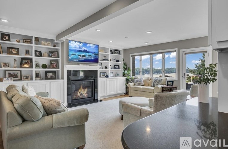 A modern living room with a fireplace and a television on the wall.