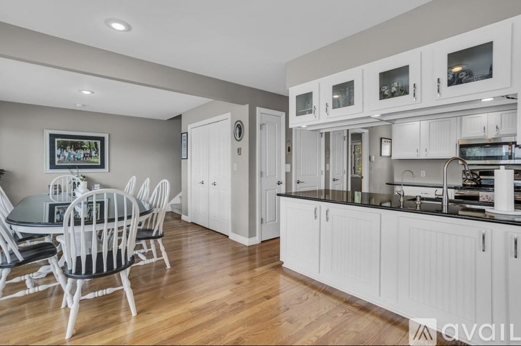 A modern kitchen with white cabinets and a dining table with chairs.