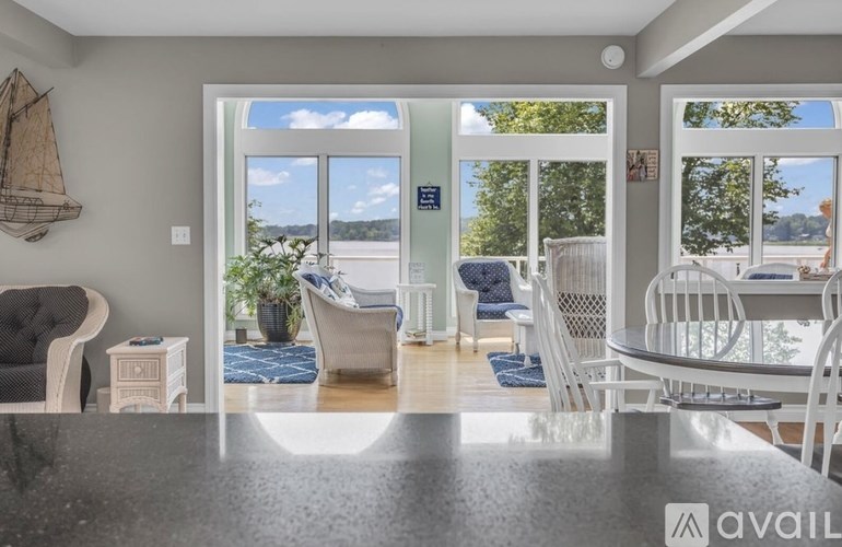 A modern dining room with a view of the outdoors through large windows.