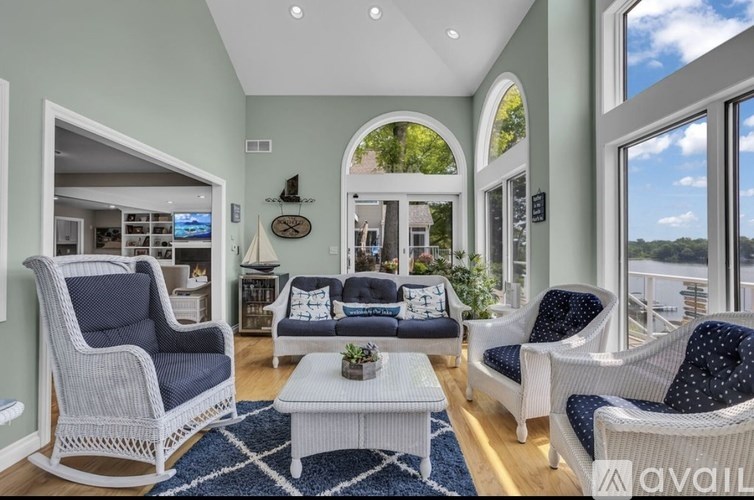 A living room with a white sofa, a blue chair, and a white coffee table.