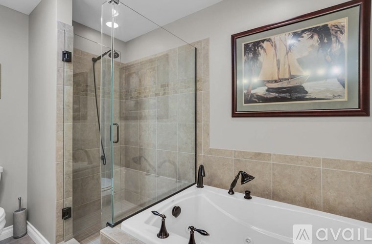 A bathroom with a glass shower door and a white bathtub.
