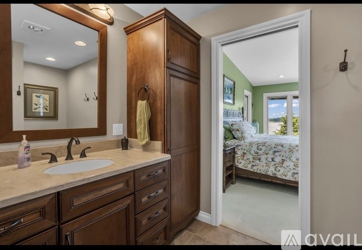 A bathroom with a sink, mirror, and wooden cabinet.