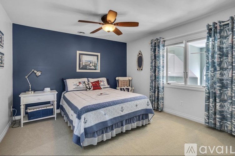 A bedroom with a bed, nightstand, and window.