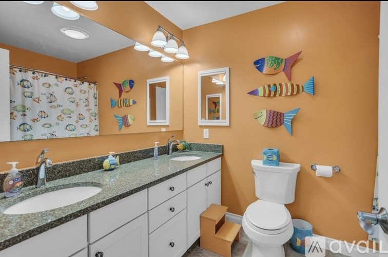 A bathroom with orange walls and a white toilet.