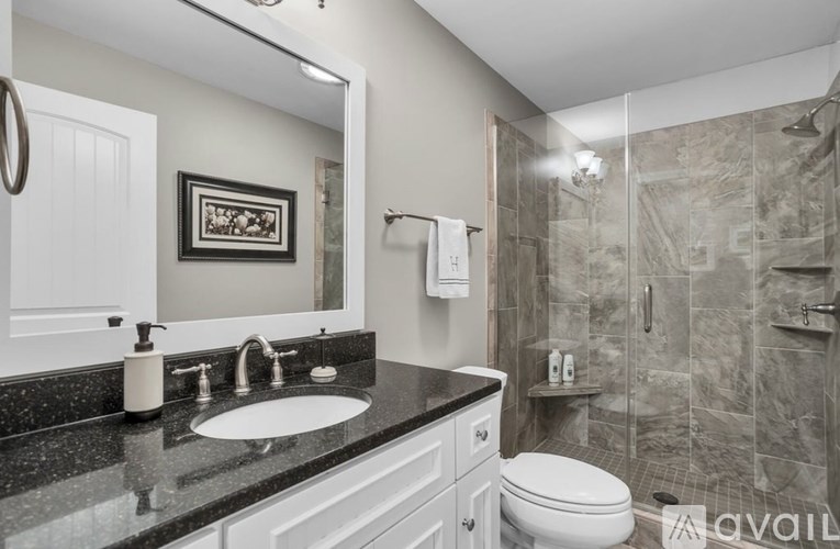 A bathroom with a sink, toilet, and shower.