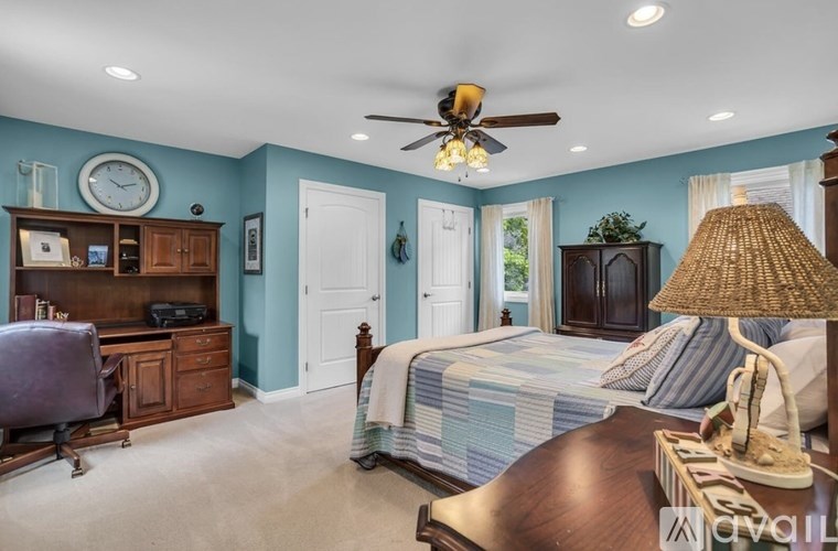 A bedroom with a bed, desk, and chair.