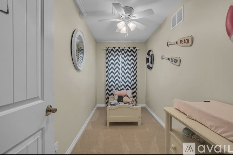 A room with a ceiling fan and a mirror on the wall.