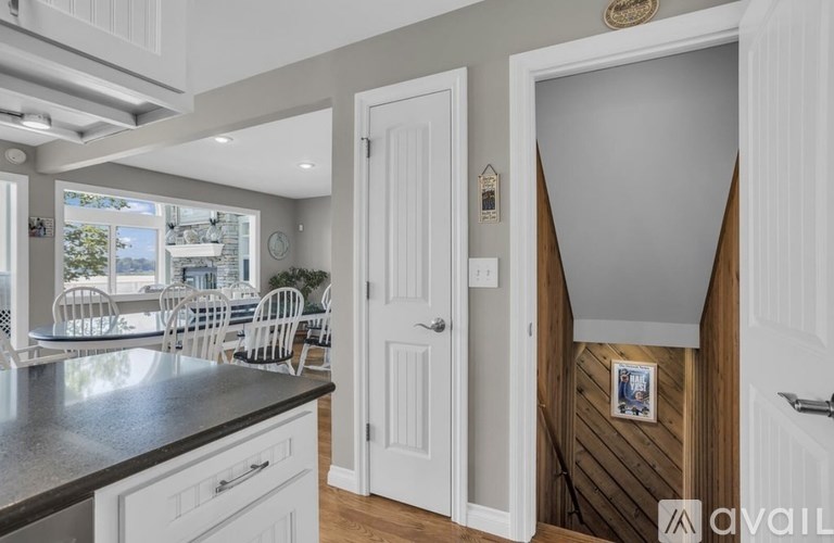 A kitchen with white cabinets and a black countertop.