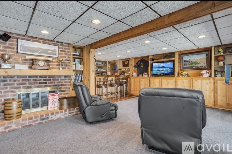 A room with a fireplace and two chairs.
