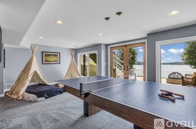 A room with a ping pong table and a teepee.