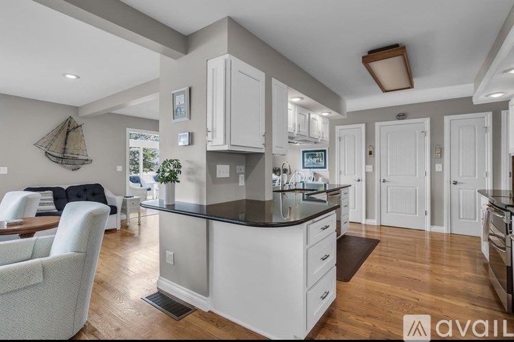 A modern kitchen with white cabinets and a black countertop.