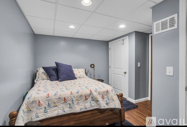 A bedroom with a bed, pillows, and a nightstand.