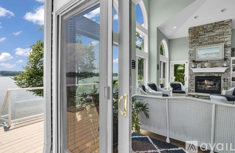 A modern house interior with a glass door leading to a balcony.