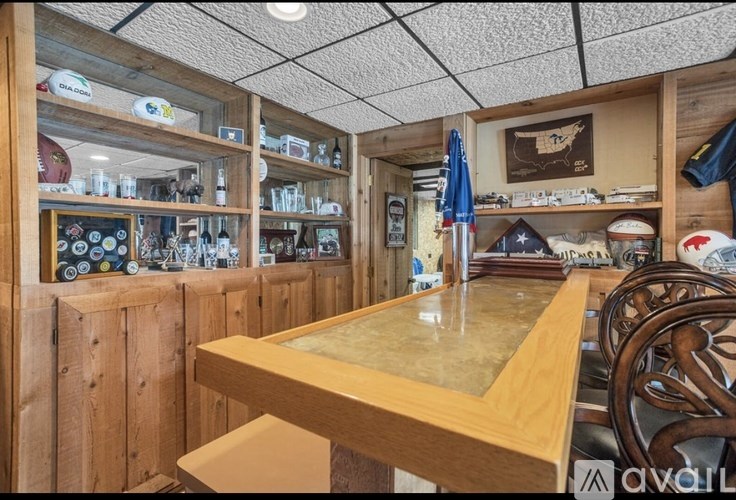 A wooden bar area with a counter and shelves filled with various items.