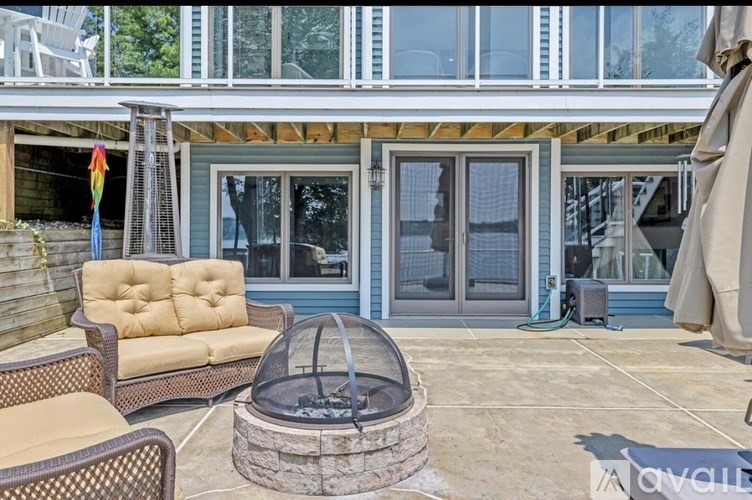 A patio with a fire pit and chairs.