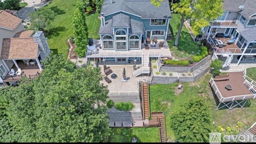A large house with a blue roof and a deck in the backyard.