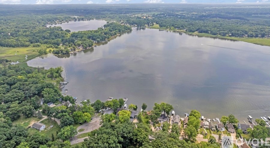 A large lake surrounded by greenery and houses.