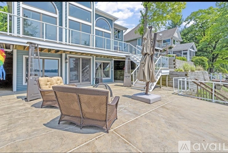 A patio with a couch, umbrella, and a table is available for rent.