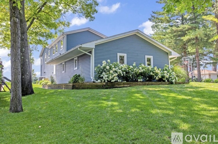 A house with a blue exterior and a well-kept lawn.