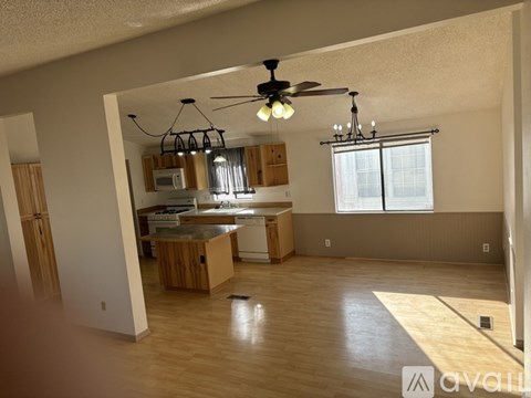 A kitchen with wooden cabinets and a ceiling fan.