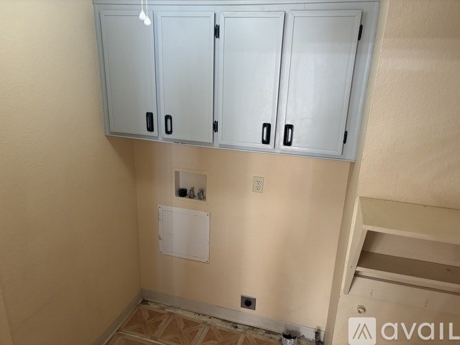 A wall-mounted cabinet with three doors and two drawers is installed above a whiteboard.