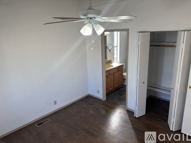 A room with a ceiling fan and a cabinet.