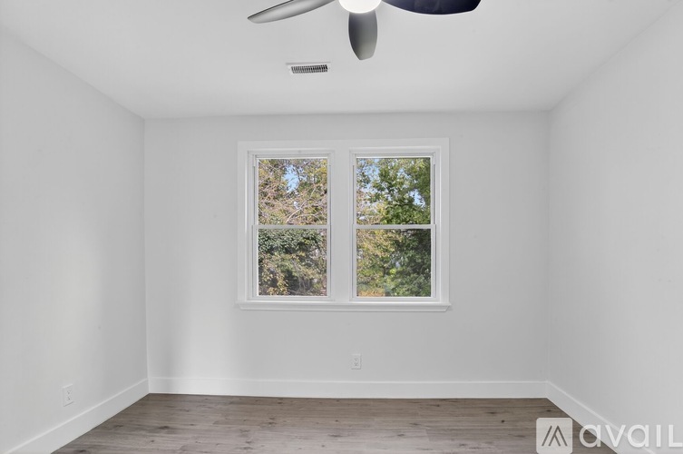 A room with a window and a ceiling fan.