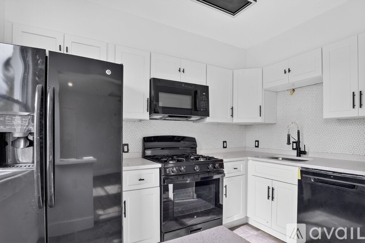 A kitchen with white cabinets and appliances.